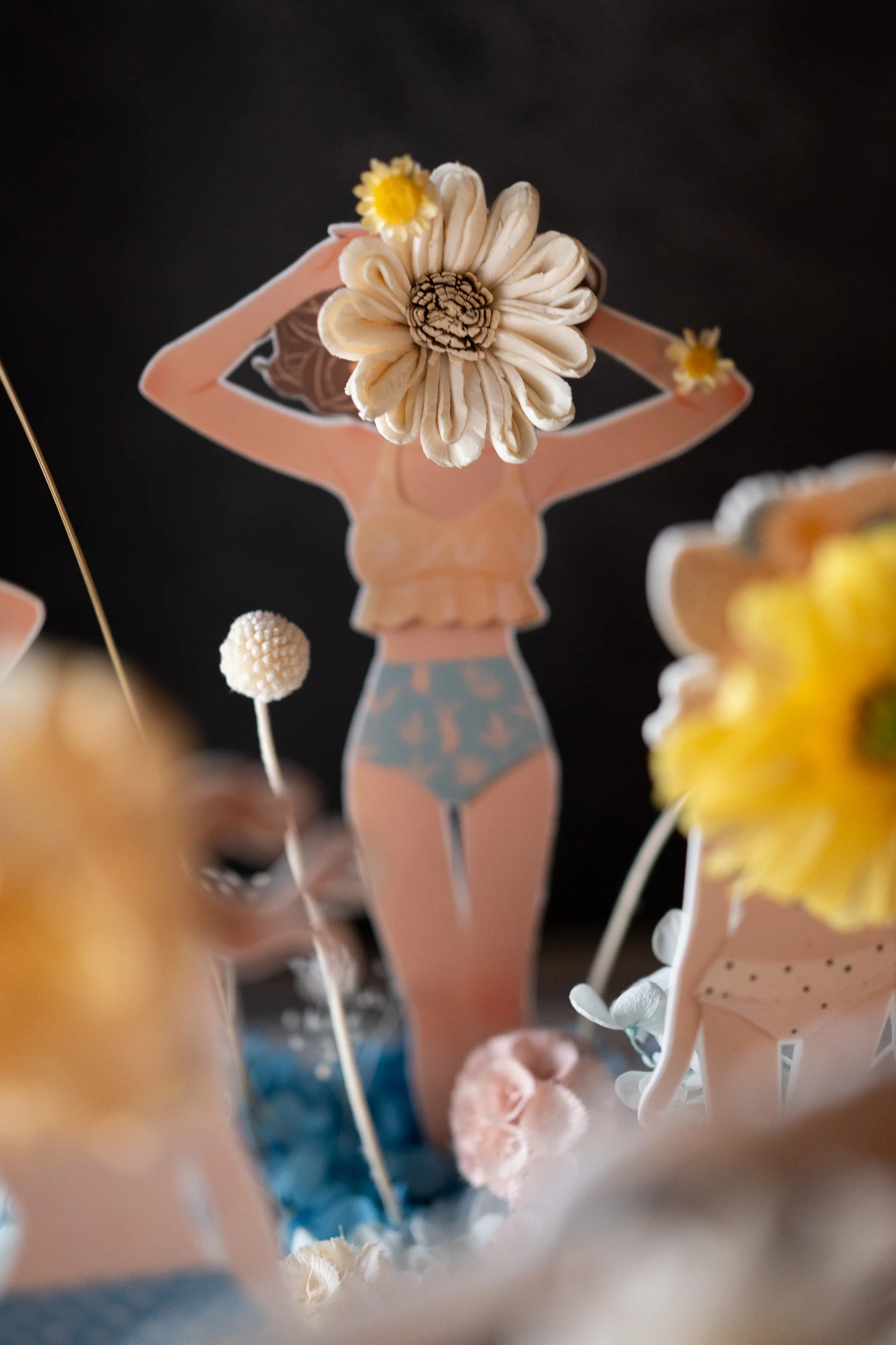 紙娃娃雙手舉起，臉部是一朵奶白色大花