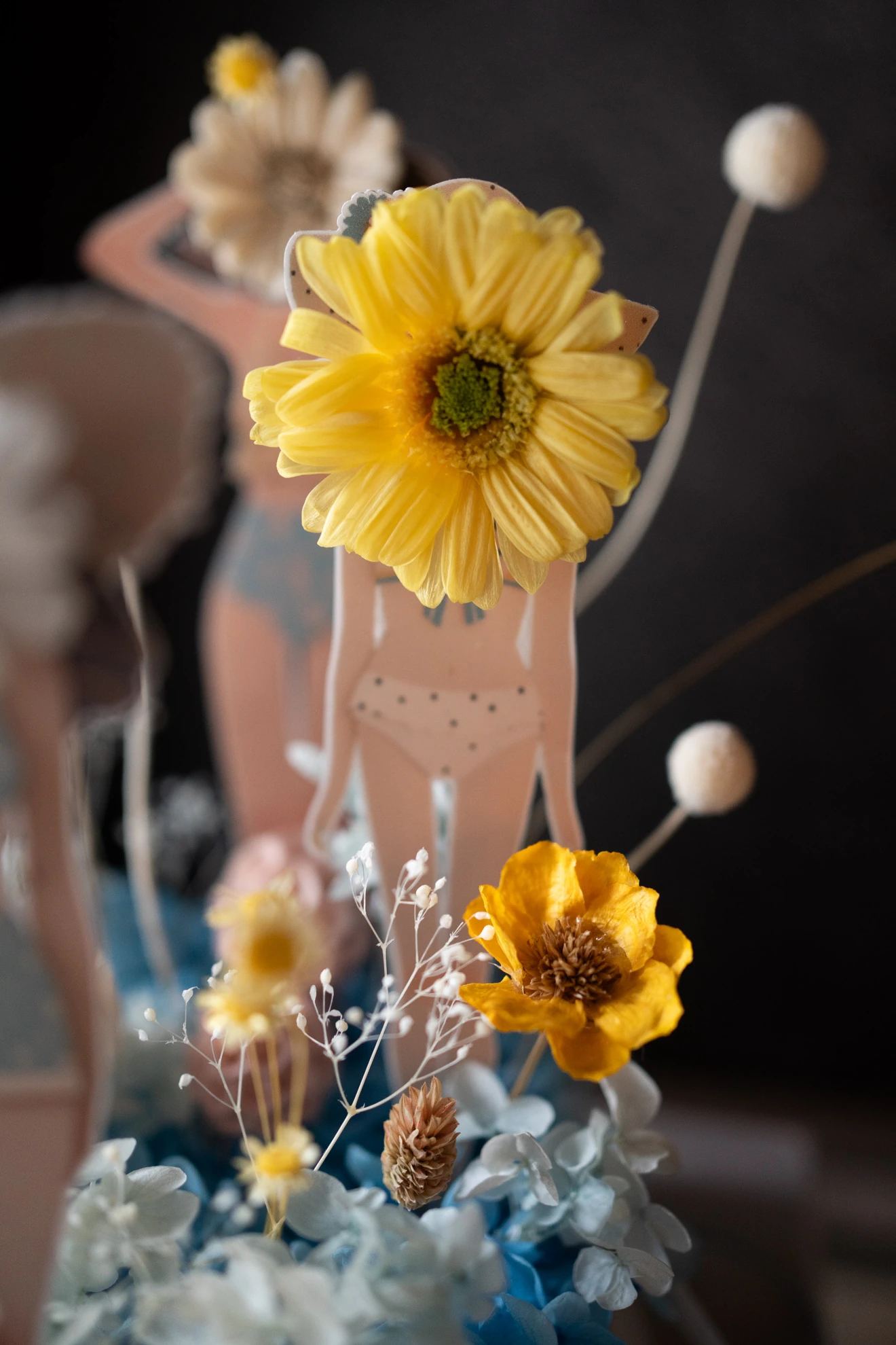 紙娃娃的臉是一朵黃色太陽花，身穿點點泳裝